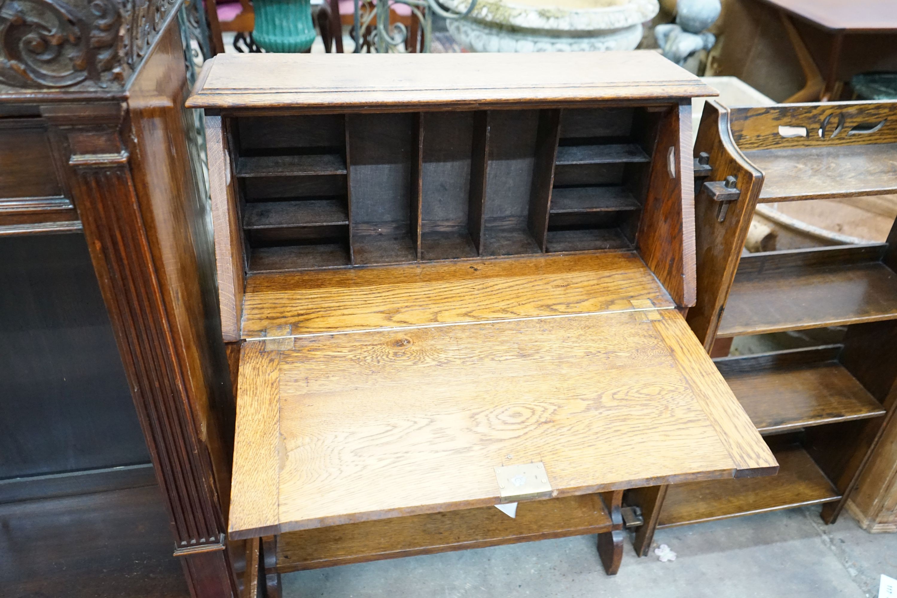 An Edwardian Art Nouveau oak student's desk, width 76cm, height 100cm together with a smaller open bookcase